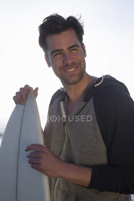 Joven sosteniendo tabla de surf, San Diego, California, EE.UU. - foto de stock