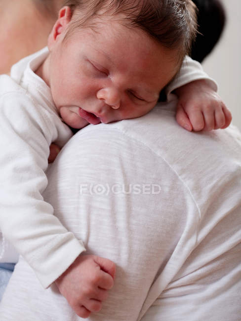 Mãe carregando bebê dormindo, foco em primeiro plano — Fotografia de Stock