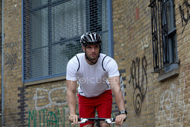 Man bicycling on city street — Stock Photo