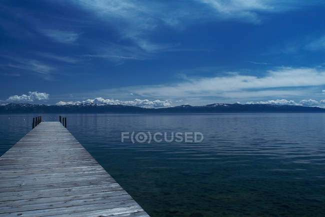 Muelle de madera en un lago tranquilo - foto de stock