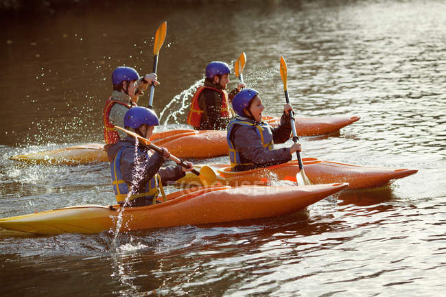 Kayakers remando juntos en un lago tranquilo - foto de stock