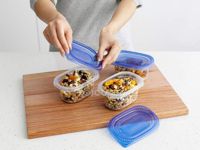 Woman packing granola in plastic containers — Stock Photo