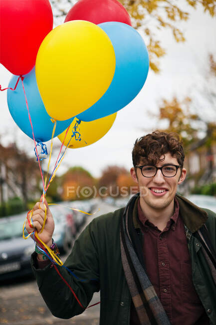 Giovanotto con palloncini colorati, ritratto — Foto stock