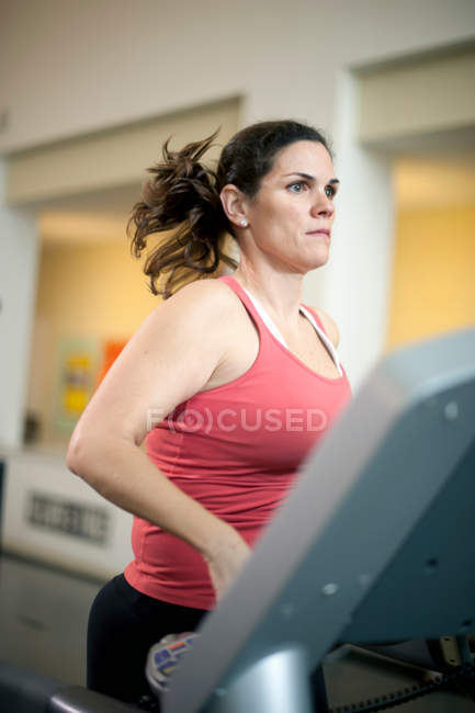 Frau benutzt Laufband im Fitnessstudio — Stockfoto