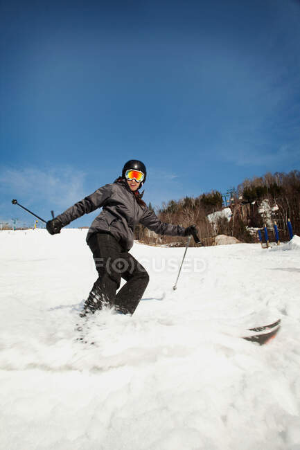 Mujer joven que enciende esquís - foto de stock