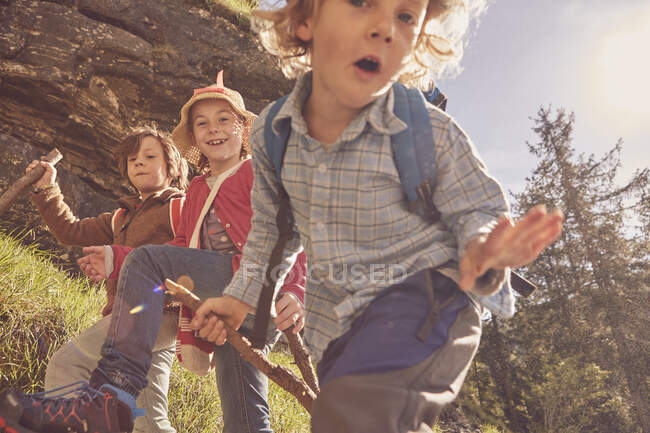 Tres niños explorando bosque - foto de stock
