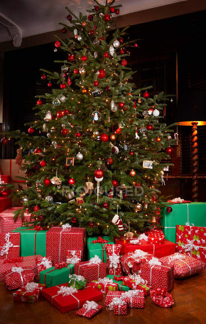 Рождественские подарки под украшенной елкой — стоковое фото
