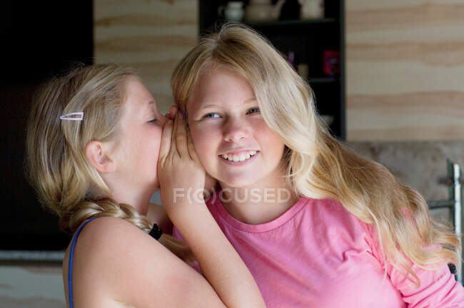 Menina sussurrando para amigo — Fotografia de Stock