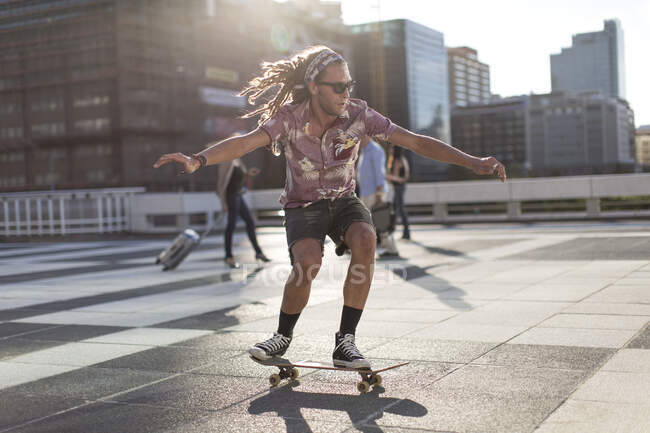 Giovane uomo in equilibrio sullo skateboard — Foto stock