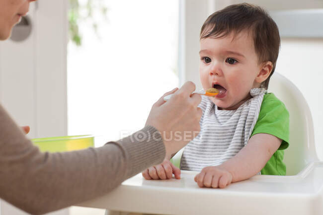 Mutter füttert kleinen Sohn — Stockfoto