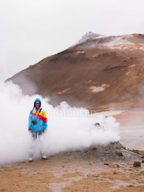 Фотограф, стоящий в дымящемся гейзере — стоковое фото