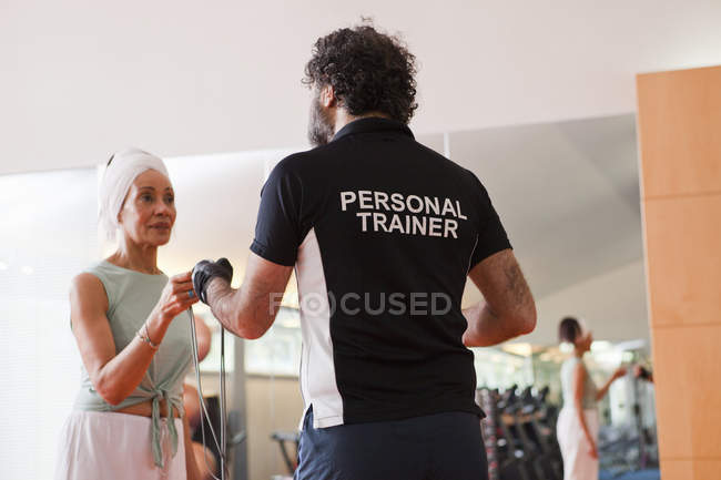 Woman working with trainer in gym — Stock Photo