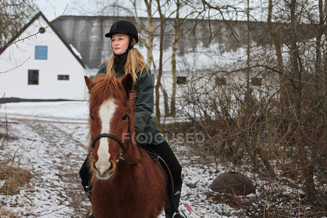 Woman riding horse in snow — Stock Photo