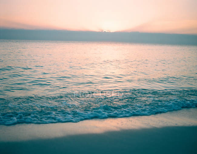 Salida del sol sobre el mar tranquilo - foto de stock