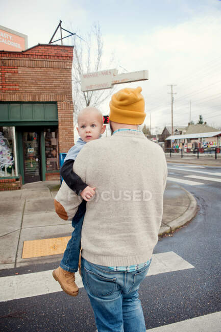 Padre che porta giovane figlio attraverso l'attraversamento pedonale — Foto stock