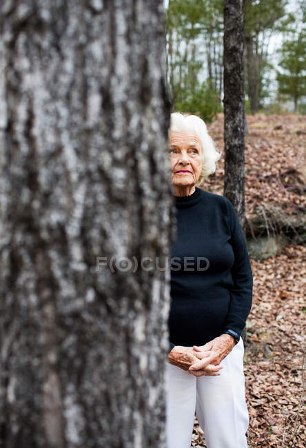 Портрет старшої жінки в лісі, застібнуті руки — стокове фото