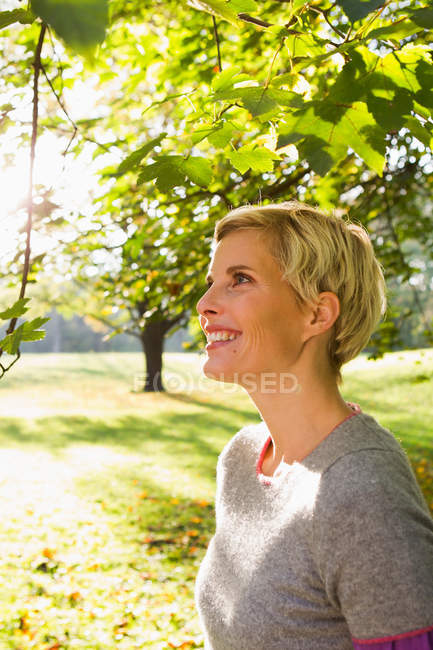 Donna sorridente nel parco — Foto stock