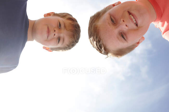 Двоє хлопців дивляться на камеру, дивиться знизу — стокове фото
