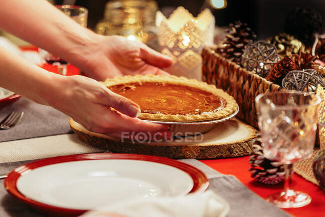 Mulher colocando torta na mesa festiva — Fotografia de Stock