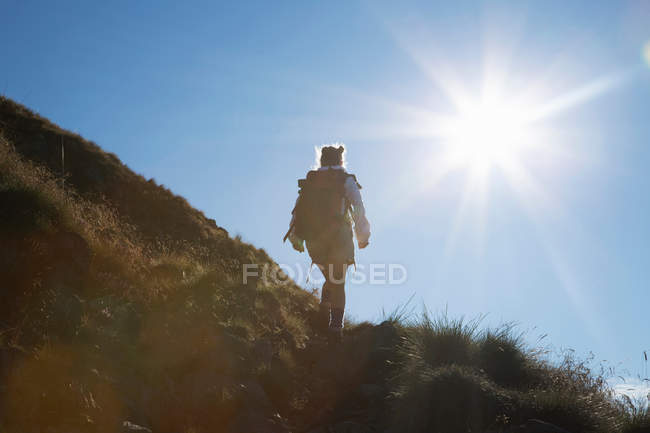 Woman hiking on rural hillside — Stock Photo