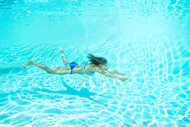 Жінка в бікіні плаває в басейні під водою — стокове фото