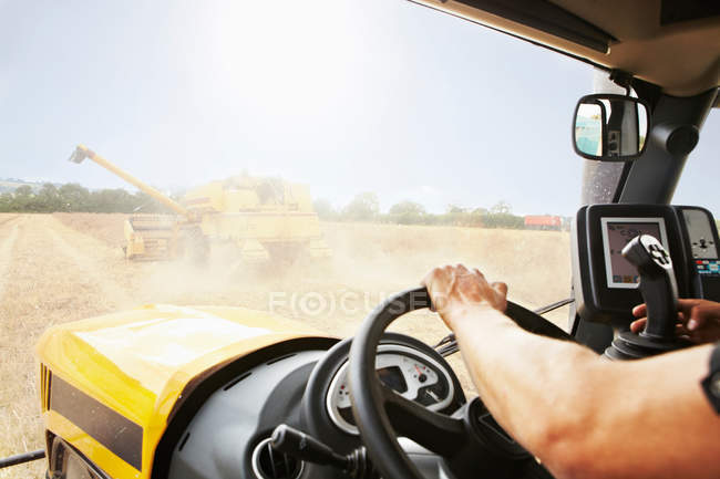 Farmer driving thresher in crop field — Stock Photo