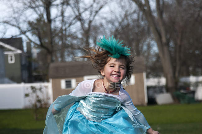 Дівчина в сукні з захоплюючим пір'ям грає на відкритому повітрі — стокове фото