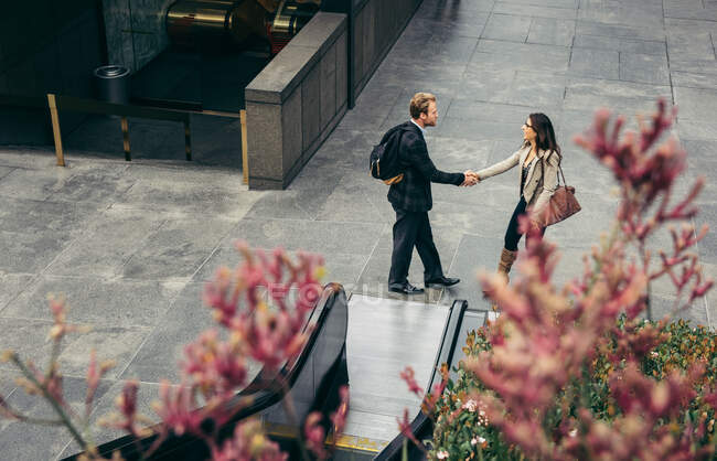 High angle view of businessman and woman shaking hands in city — Stock Photo