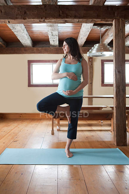 Mujer embarazada haciendo yoga - foto de stock