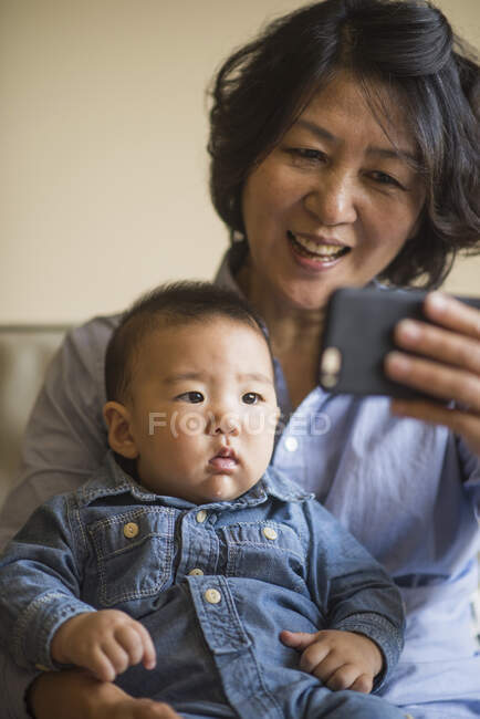 Бабуся показує смартфон онуку — стокове фото