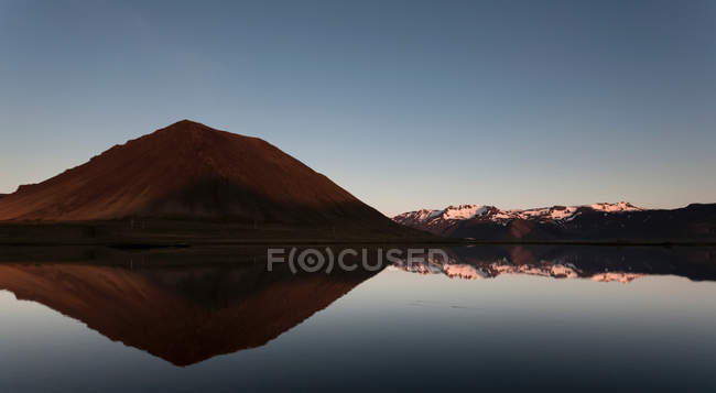 Cielo y montañas reflejados en el lago - foto de stock