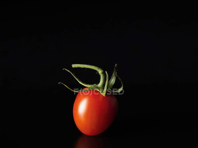 Ripe tomato on black — Stock Photo