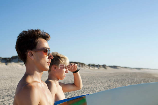 Dos jóvenes surfistas se dirigen al mar - foto de stock