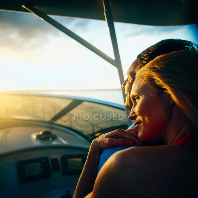 Mulher relaxante no ombro do homem no barco com pouca luz — Fotografia de Stock