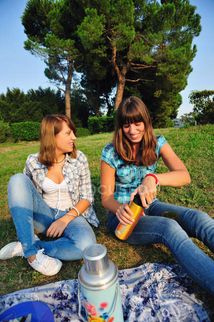 Teenage girls picnicking in rural field — Stock Photo
