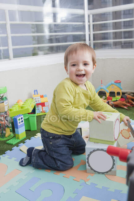 Дитячий хлопчик укладає гральні блоки вдома — стокове фото