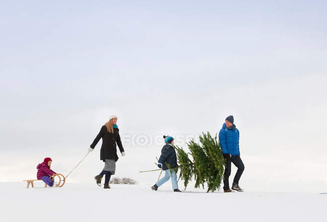 Famille marchant ensemble dans la neige — Photo de stock