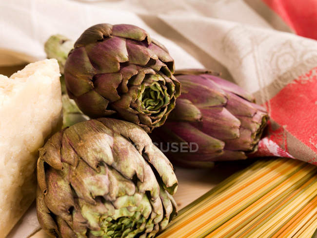 Alcachofas y pasta en la mesa - foto de stock