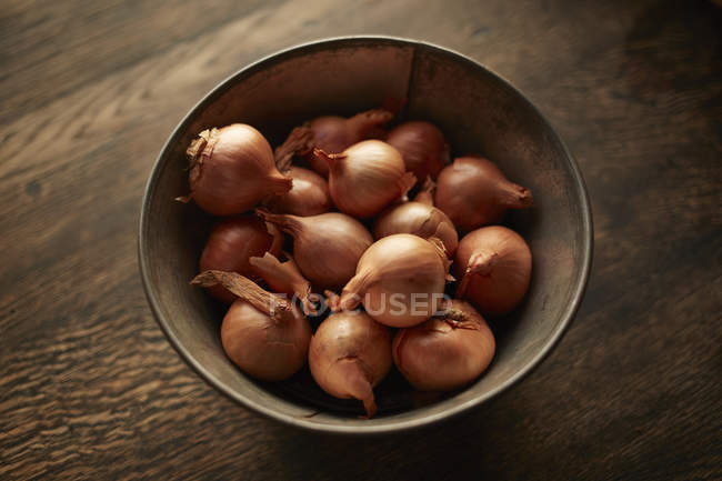 Overhead view of fresh whole shallots in bowl — Stock Photo