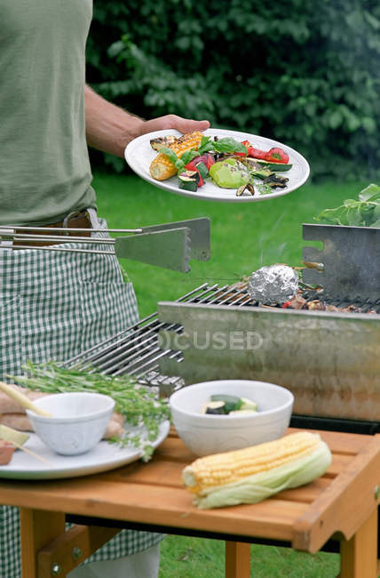 Homme servant barbecue repas sur assiette — Photo de stock