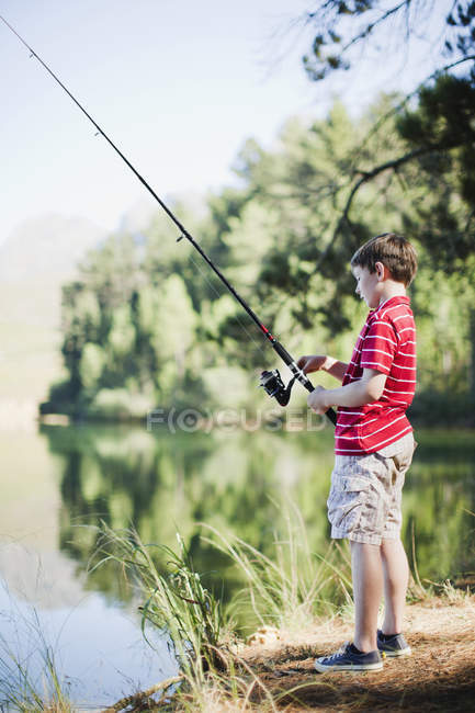 Petit garçon pêche dans le lac — Photo de stock