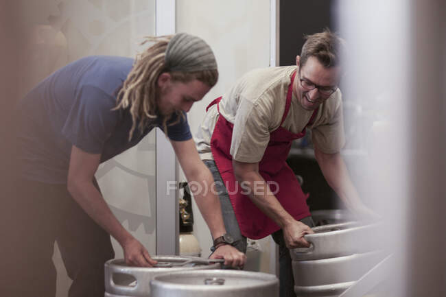 Cape Town, South Africa, two males picking up containers in brewery room — Stock Photo