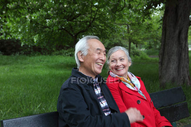Пари дорослих, сидячи на лавці в парку — стокове фото