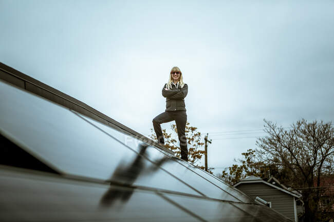 Ritratto di donna adulta di mezza età in piedi sul tetto della casa rivestita di pannelli solari — Foto stock