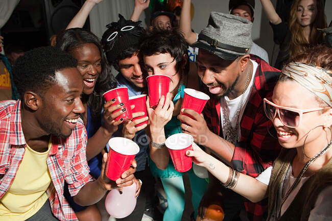 Jovens com copos de plástico na festa — Fotografia de Stock