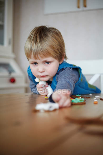Girl decorating gingerbread cookies — Stock Photo