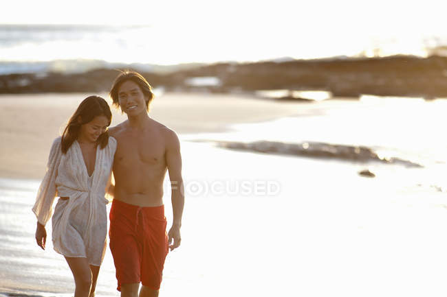 Пара прогулок вместе на пляже, фокус на переднем плане — стоковое фото