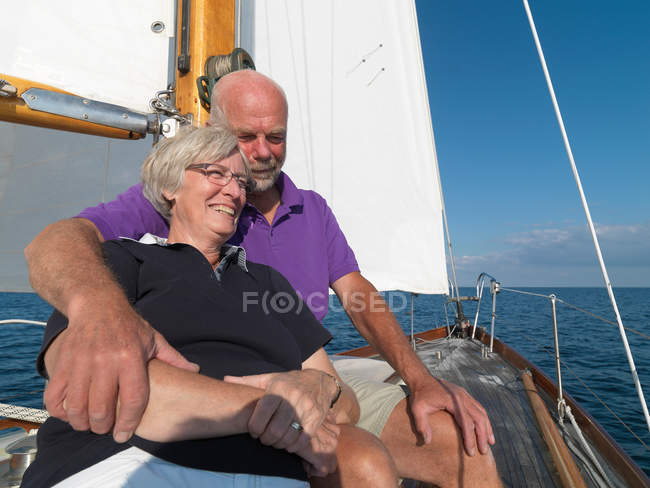 Older couple relaxing on sailboat — Stock Photo