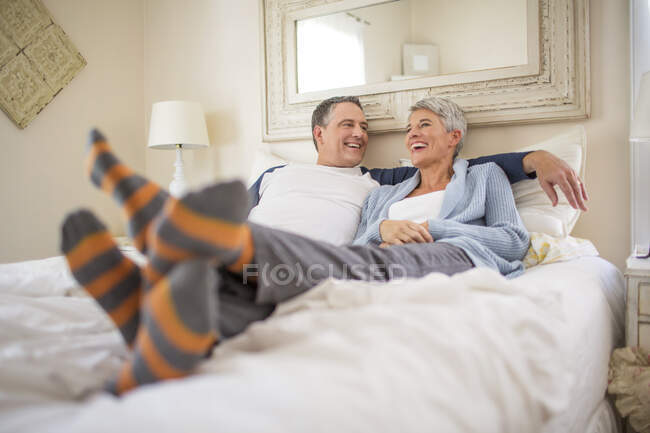 Зрелая пара болтает и отдыхает в постели — стоковое фото
