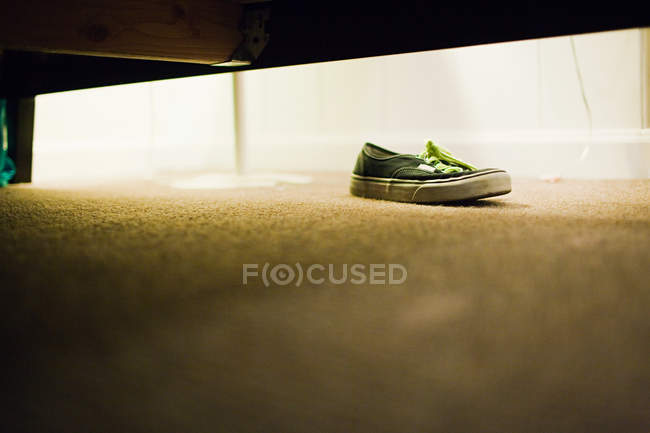 Vista de nível de superfície do sapato sob a cama — Fotografia de Stock